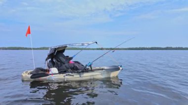 Gölde çubuklarla kano süren bir kadın, balık tutuyor. Balıkçı kadın güneşli yaz gününde gölde balık pedalı PDL kayığında kano tutuyor ve kano tutuyor. Kano balıkçılığı yaz sporları.