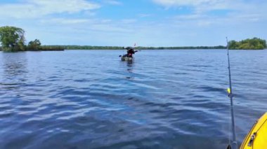 Yaz macerası sırasında gölde kano üzerinde kano sürmek, seyahat konsepti. PDL Drive balıkçı kanosu ve balıkçı teknesi gölde balık tutarken sürükleniyor. Kanoda balık tutmak..