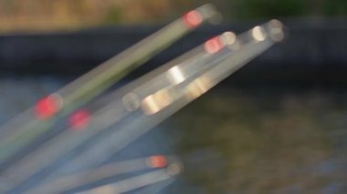 Dönen balıkçılığın tepelerine odaklan. Monofilament çizgileri ve bulanık göl arkaplanının üzerinde örgü olan döküm çubukları. Balıkçılık arka planı, seçici odak ve rüzgarda yavaş çekim hareketi.