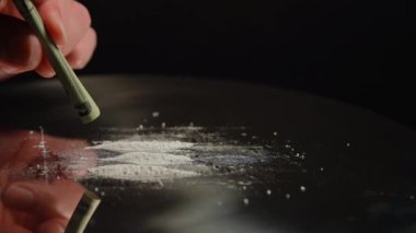 Kokain çekmek için masaya dökülen toz reçeteli opioid oksikodon haplarına çarpılmış. Opioidler bağımlılığa, bağımlılığa ve aşırı doza neden olur. Ulusal Opioid Farkındalık Günü. Potansiyel taraf riskleri etkiler.