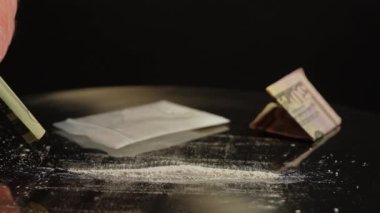 Kokain çekmek için masaya dökülen toz reçeteli opioid oksikodon haplarına çarpılmış. Opioidler bağımlılığa, bağımlılığa ve aşırı doza neden olur. Ulusal Opioid Farkındalık Günü. Potansiyel taraf riskleri etkiler.