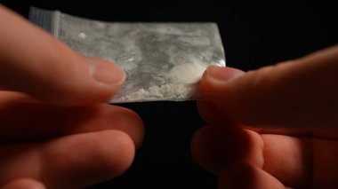 Uyuşturucu bağımlısı biri az önce sokaktaki satıcıdan yasadışı eroin ya da fentanil aldı ve ona baktı. Parti yapmaya hazır bir insan. Yasadışı uyuşturucu salgını. 