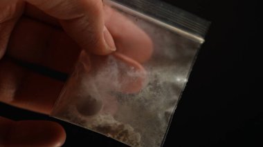 Ezilmiş kokain tozu sokakta satılmak üzere küçük plastik torbalarda kristalize edilmiş. Beyaz toz, yasadışı uyuşturucu. Bağımlılık ve yasadışı uyuşturucu, bağımlılık ve kaçakçılıkla mücadele.