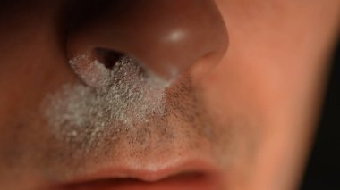 Nose in powder, man get high on illegal street drug, touching his nose in white powder after snorting strips. Abuse of crushed opioid drugs. Addiction and illicit drugs. Struggles of addiction.  clipart