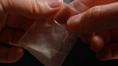 Ezilmiş kokain tozu sokakta satılmak üzere küçük plastik torbalarda kristalize edilmiş. Beyaz toz, yasadışı uyuşturucu. Bağımlılık ve yasadışı uyuşturucu, bağımlılık ve kaçakçılıkla mücadele.