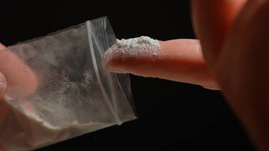 Uyuşturucu bağımlısı biri az önce sokaktaki satıcıdan yasadışı eroin ya da fentanil aldı ve ona baktı. Parti yapmaya hazır bir insan. Yasadışı uyuşturucu salgını. 
