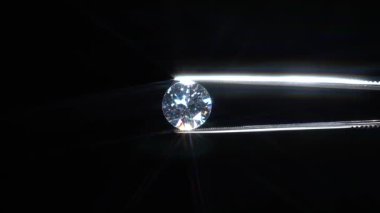 Elleri cımbızla tutulmuş elmas kalite teftiş, seçici odaklanma. Çipler ve hasar yukarı bakın. Makro, lüks dahice yakın plan. Büyüteçle bak. Yuvarlak kesim taş mücevherler. Nişan Günü