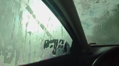 Car washing in the touch less car wash. No brushes used to wash the vehicle to preserve the exterior from damage. View from the driver cabin. Self served