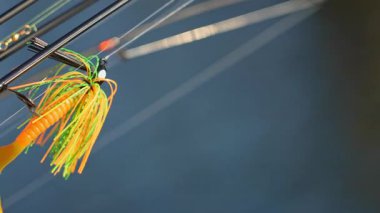 Plastik tuzaklı oltalar, seçici odaklanma, bulanık bir arka plan. Makro, Jig kafaya yakın, kuyruklu, yumuşak solucanlar ve balık yemi Minnow ile. Rüzgarda ağır çekim hareketi.