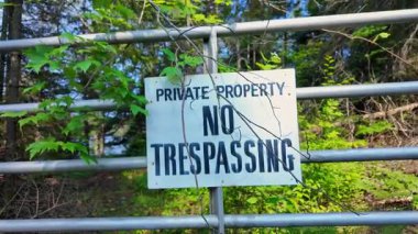 Kanada, Kuzey Amerika 'daki Ontario Eyaleti' nin Crown Land Ormanı 'ndaki metal çit kapılarında özel mülk ihlali yok tabelası var. Kırsal derin orman bölgesi.