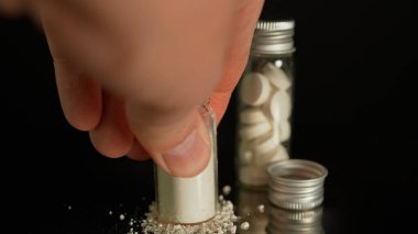 Bardak şişesinde depolanan yasadışı uyuşturucu madde kullanımına işaret ediyor. Uyuşturucu ve fentanil içeren devam eden bir kriz. Bir konteynıra yerleştirilmiş eroin ya da ezilmiş oksikodon..