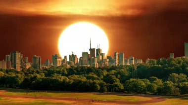 Sinema güneşi kırmızı sarı ve turuncu şehir gökyüzünde batıyor. Sıcak yaz atmosferi ve ısı dalgası sisinden oluşan sanatsal efektler. Sarı güneş destansı altın saat hızında batıyor. Büyük güneş diski.