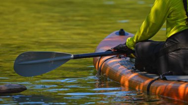 Manitou Gölü, Manitoulin Adası, bir kadın spor aletleri, dalgıç kıyafeti ve kürek çekmek için can yeleği ile SUP sörf tahtasına biniyor. Kalk ayağa, sörf tahtası aktif eğlence ve spor gölde..