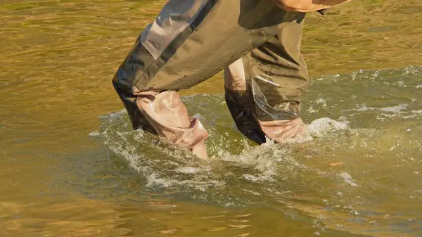 Tanınmayan balıkçı ya da balıkçı balıkçı, kayalık kayalık nehir ya da derede balık tutmak için balıkçı çizmeleriyle yürür. Balıkçılar için balık avı ve spor.