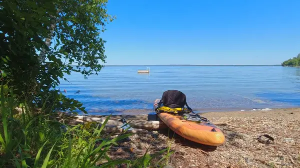 Spor aletleri, açık hava aktiviteleri, sarı su geçirmez çanta, sakin göl suyunda kürek çekme. Su sporu ve hobi aletleri. Kanada 'da seyahat ve macera. 