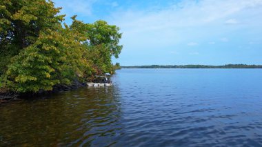 Kuzey Amerika göl manzarasının destansı su yüzeyi, Kanada 'da yaz manzaraları. Düşük irtifada parlak mavi gökyüzü ve su.