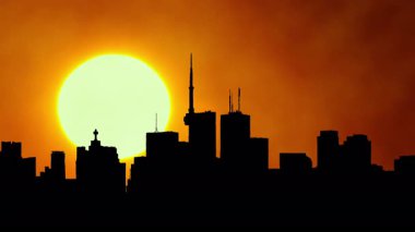 Şehrin ufuk çizgisi silueti, sıcak sinematik güneş batımı, şehir merkezi, büyük güneş batımı ışığı olan şehir merkezi. Sanatsal efektler. Binalar ve sarı güneş diskleriyle destansı sıcak yaz gökyüzü. Isı dalgası uyarısı.