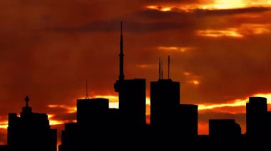 Kuzey Amerika silueti silueti gün batımı zamanı. Şehir kuleleri ve şehir manzarası, güneş batarken renkli sıcak bulutlarla doluyor. Amerikan şehir merkezindeki sanat kolajının üzerine güneş battı. Sis 'in özel efektleri.