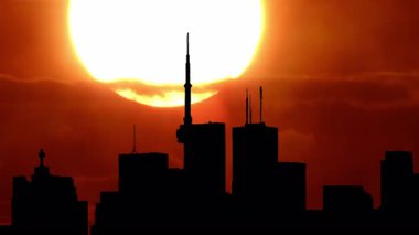 Kuzey Amerika silueti silueti gün batımı zamanı. Amerikan şehir merkezindeki sanat kolajının üzerine güneş battı. Sis 'in özel efektleri. Şehir kuleleri ve şehir manzarası güneş batarken renkli sıcak bulutlarla doluyor..