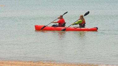 Viking Octantis 'in turist yolcuları iki koltuklu bir kanoya kürek çekiyor. Ana gemi, Point Peele, Leamington, Ontario, Kanada - 23 Haziran 2023.