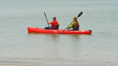 Viking Octantis 'in turist yolcuları iki koltuklu bir kanoya kürek çekiyor. Ana gemi, Point Peele, Leamington, Ontario, Kanada - 23 Haziran 2023.