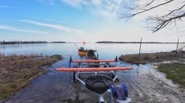Balıkçı kanoları göl kıyısındaki denize açılmak ve balık tutmak için hazırlandı. Rampa su girişindeki tekne römorku kamyon otostop ve balıkçı kanolarına bağlı. Baharda spor balığı turnuvası.