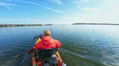Balıkçılar ya da balıkçılar göl suyunda balık avı turnuvasındayken motorlu pedallarla kano balıkçılığı yapıyorlar. Kano balıkçılığı ve su sporu. Baharda su sporu.