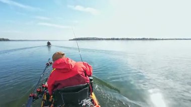 Balıkçılar ya da balıkçılar göl suyunda balık avı turnuvasındayken motorlu pedallarla kano balıkçılığı yapıyorlar. Kano balıkçılığı ve su sporu. Baharda su sporu.