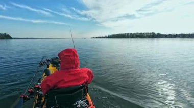 Balıkçılar ya da balıkçılar göl suyunda balık avı turnuvasındayken motorlu pedallarla kano balıkçılığı yapıyorlar. Kano balıkçılığı ve su sporu. Baharda su sporu.