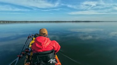 Balıkçılar ya da balıkçılar göl suyunda balık avı turnuvasındayken motorlu pedallarla kano balıkçılığı yapıyorlar. Kano balıkçılığı ve su sporu. Baharda su sporu.