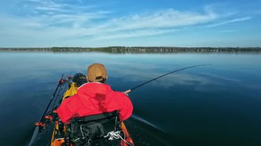 Balıkçılar ya da balıkçılar göl suyunda balık avı turnuvasındayken motorlu pedallarla kano balıkçılığı yapıyorlar. Kano balıkçılığı ve su sporu. Baharda su sporu.
