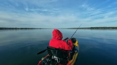 Kano balıkçısı gölde balık tutmak için kano, olta ve küçük yem kullanıyor. Balıkçı, Kuzey Amerika sularında kano yapıyor, balık tutuyor ve balık tutuyor. Baharda su sporu. Balıkçılık oyunu.