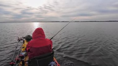 Balıkçılar ya da balıkçılar göl suyunda balık avı turnuvasındayken motorlu pedallarla kano balıkçılığı yapıyorlar. Kano balıkçılığı ve su sporu. Baharda su sporu.