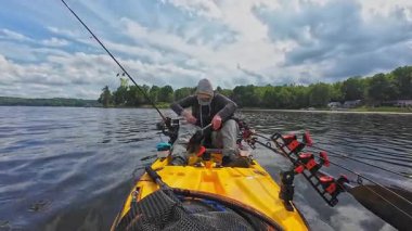 Balıkçı ya da levrek turnuvası balıkçısı güneş maskeli, göl otlarından motorlu kano motoru temizleyen bir rakip. Balıkçılık yarışması, eğlence amaçlı su sporları.
