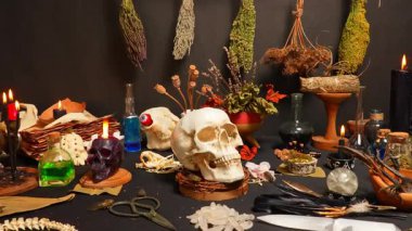 İnsan kafatası siyah, seçici odaklı, sihirli gizemli ritüel aletleri ve eşyalarla çevrili. Okült büyü çalışması ve bilgi. Mistisizm doğaüstü bilim. Büyücülük ve büyücülük..