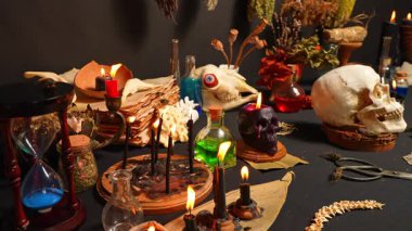 Kara büyü mumları büyücülük kompozisyonu. Seçici odaklanma. Sihirli ayin şeytani aletler ve eşyalar. Cadılar Bayramı ve okült kara büyü ritüeli hayali. Karanlık ve korkutucu atmosferde ayin sahnesi.