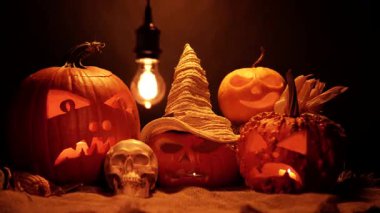 Cadılar Bayramı turuncu balkabakları yanan mumlarla yanıp sönüyor. Mevsimsel bayram kutlaması için dehşet ayarlandı. Fener gülüşü ve korkunç gözler oyulmuş. Ruhlar gecesi.