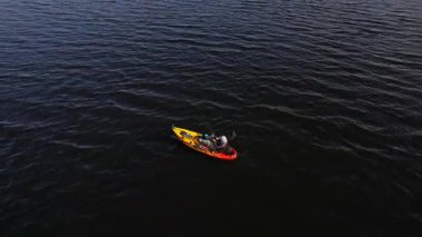 Kuzey Amerika gölünde bir kano, kayaklı bir adam. Kanada güneşli gün batımı ve macera yolculuğu. Güç sporu, kano balıkçılığı, balıkçılık insansız hava aracı görüntüsü. Kişisel su araçlarında eğlence ya da spor.