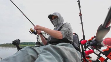 Kanodaki balıkçı, ağzında kanca ve solucan yemi, yaz aktivitesi, kano ve açık havada balık tutarak güzel bir mavi balık yakalar ve bırakır. Kano balıkçısı avını gösterir ve bırakır..