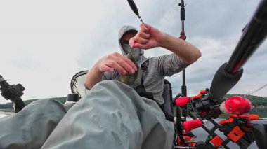 Kanodaki balıkçı, ağzında kanca ve solucan yemi, yaz aktivitesi, kano ve açık havada balık tutarak güzel bir mavi balık yakalar ve bırakır. Kano balıkçısı avını gösterir ve bırakır..