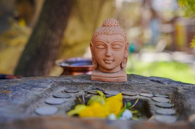 Bahçesinde su olan Buda heykeli.