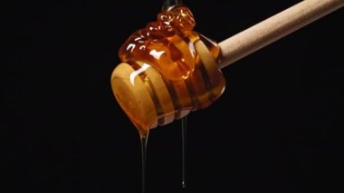 Turuncu Bal Ahşap Kaşıkla Siyah Arkaplanda Akıyor. Yüksek kalite 4k görüntü
