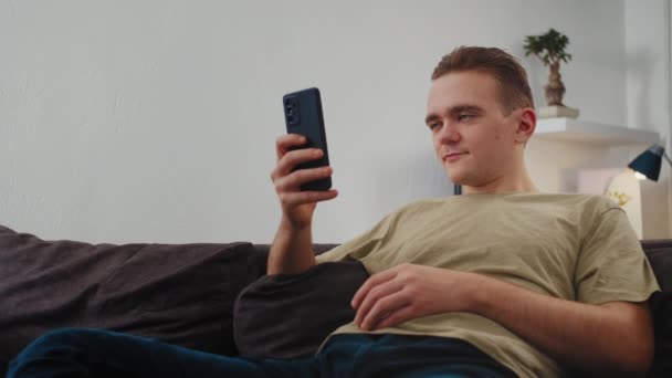 Teenager Giovane Uomo Guarda Telefono Surf Internet Cerca Shopping Annoiato — Video Stock