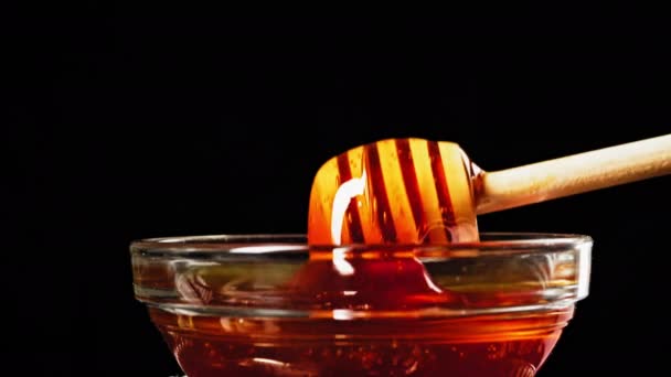ガラスカップ プラスチックリサイクルに木製の蜂蜜スティック上を流れる甘い蜂蜜 高品質4K映像 — ストック動画