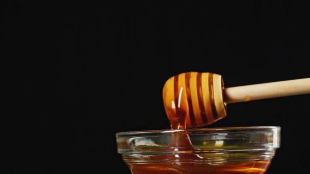 橙色甜蜂蜜流过木制蜂蜜粘在玻璃杯 塑料回收 高质量的4K镜头 — 图库视频影像