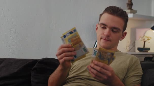 Tânărul Stă Acasă Canapea Considerare Banii Euro Este Foarte Încântat — Videoclip de stoc