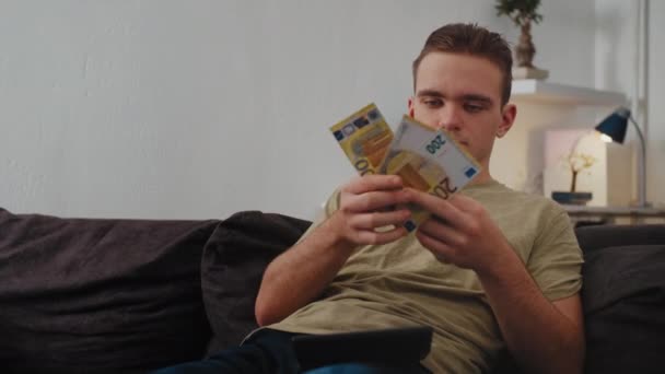 Genç Bir Adam Parasını Hesap Makinesiyle Değerlendirir Sevinir Yüksek Kalite — Stok video