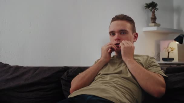 Der Kerl Sitzt Auf Der Couch Verdeckt Sein Gesicht Mit — Stockvideo