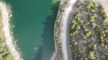 4k Drone Video, turkuaz su ve toprak yol manzaralı kırsal bölge.