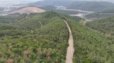 4k drone videosu: İHA hareketi dağ sırasındaki toprak yolu takip ediyor.